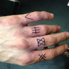 Męski tatuaż na palcach z symbolami. Cztery palce zdobią czarne, geometryczne wzory, każdy inny.