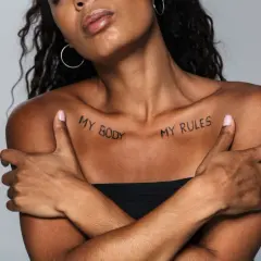 Kobieta z tatuażem na obojczyku: "MY BODY MY RULES". Wyrazisty napis, podkreślający siłę i autonomię.