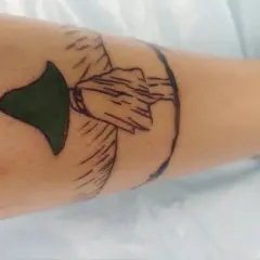 Nowy tatuaż muminki na nodze. Zielony kapelusz i zarys postaci.