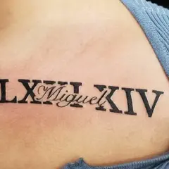 Tatuaż cyfry rzymskie LXIII i XIV z imieniem Miguel. Eleganckie wzory na skórze.