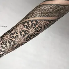 Rękaw pokryty misternym dotwork tattoo z geometrycznymi wzorami, tworzącymi iluzję przestrzeni i ruchu.