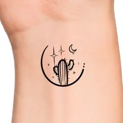 Minimalistyczny kaktus tatuaz na nadgarstku, otoczony księżycem i gwiazdami.
