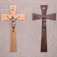 Dwa drewniane krzyże z figurkami Jezusa. Jeden jasny, drugi ciemny. Symbol wiary, jak tatuaż krzyż na palcu znaczenie.