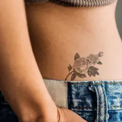 Delikatny tatuaż z różami na boku, jeden z najpiękniejszych tatuaży damskich, subtelnie zdobi skórę.