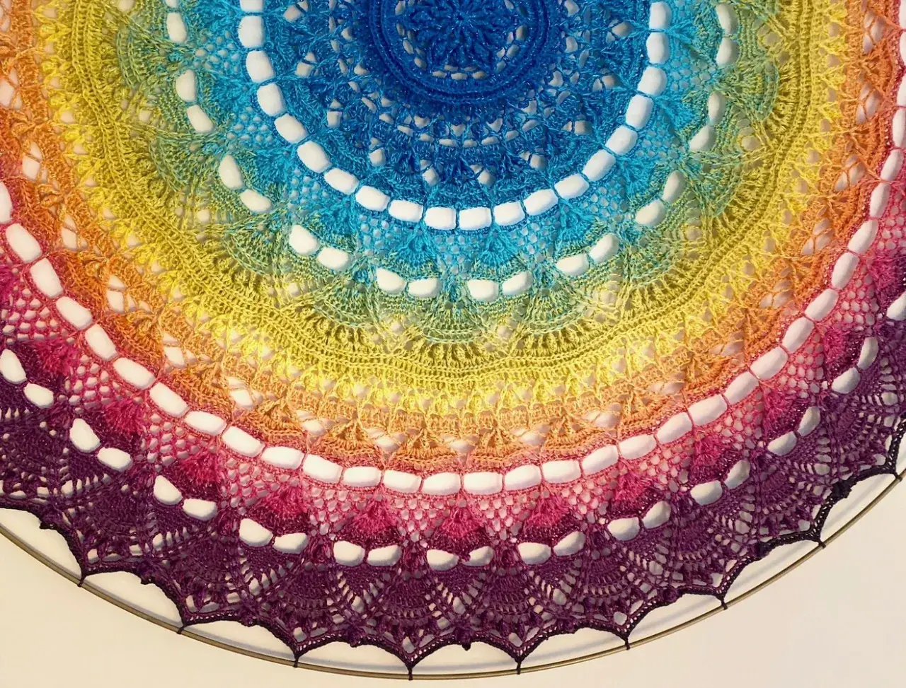 Kolorowa, tęczowa mandala z koronki, niczym tatuaż mandala między piersiami, ozdobiona misternym wzorem.