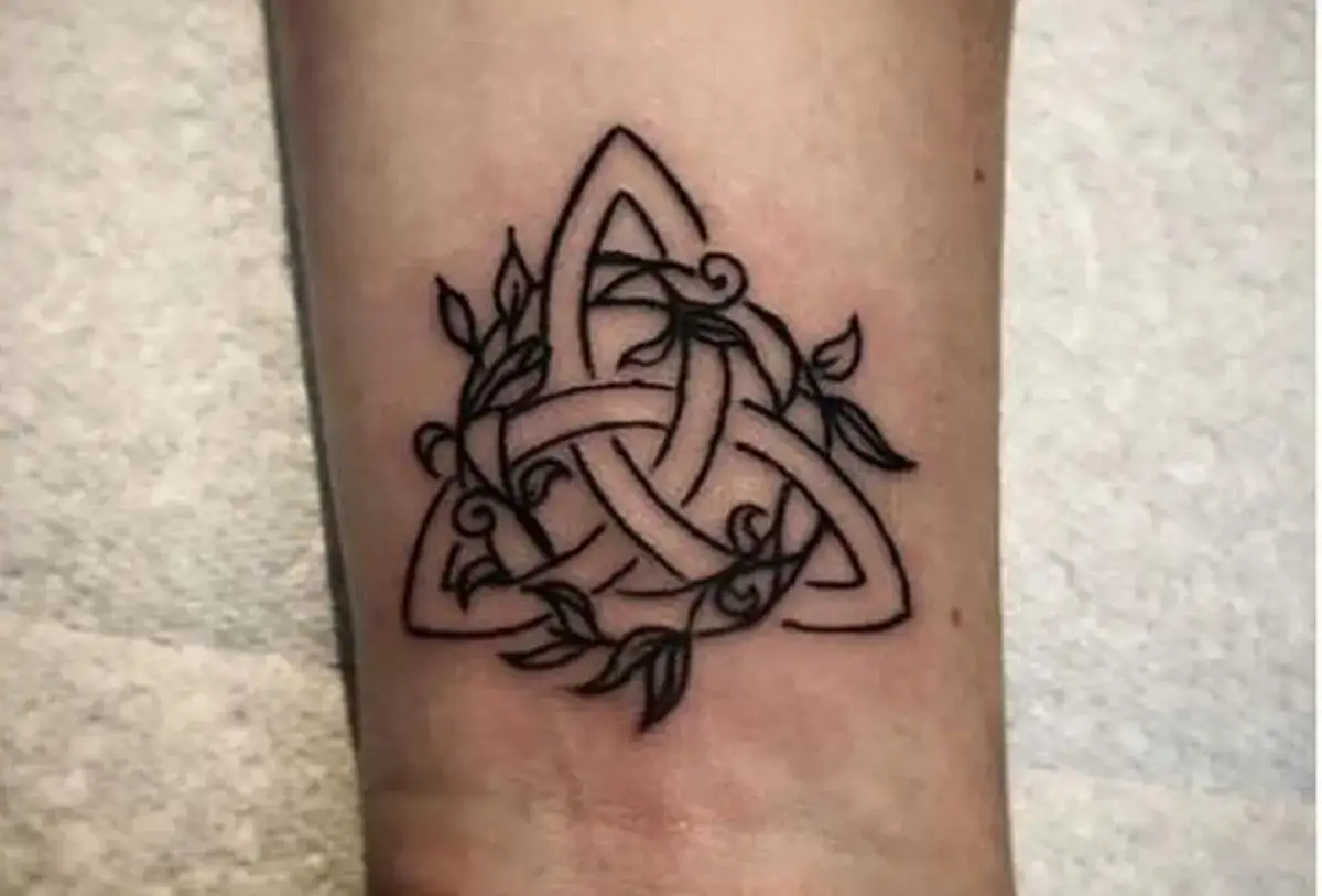 Tatuaże celtyckie znaczenie: węzeł triquetra ozdobiony liśćmi, symbol wieczności i połączenia.