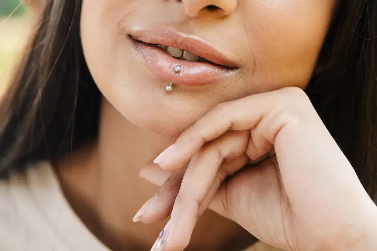 Usta z kolczykiem labret. To ozdoba przekłuta w wardze, często noszona jako wyraz indywidualności.